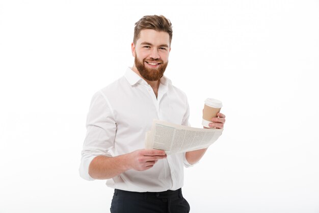 Smiling bearded man in business clothes holding newspaper