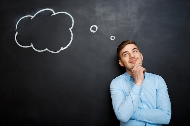 Free photo smiling bearded man shouting and standing over blackboard backgr