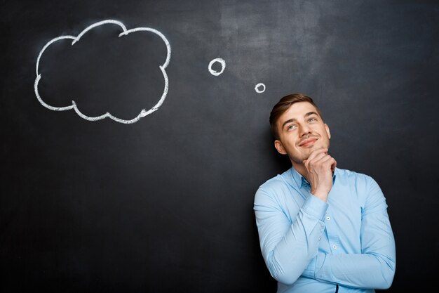 smiling bearded man shouting and standing over blackboard backgr