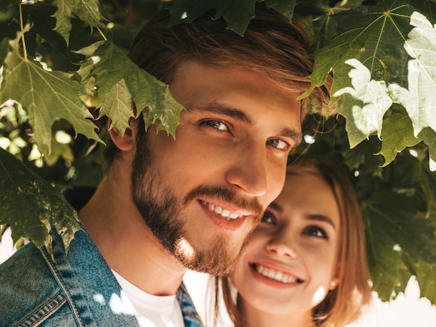 Free photo smiling beautiful girl and her handsome boyfriend posing in the street near tree.