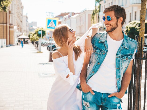 Smiling beautiful girl and her handsome boyfriend posing in the street.