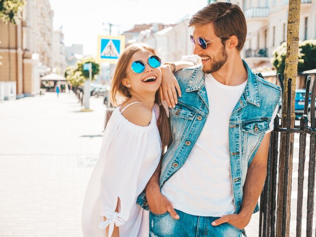 Smiling beautiful girl and her handsome boyfriend posing in the street. 