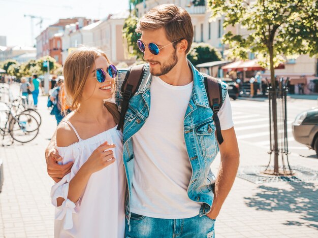 Smiling beautiful girl and her handsome boyfriend walking in the street.