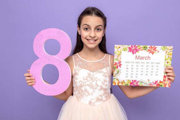 Smiling beautiful little girl on happy women's day holding number eight with calendar 