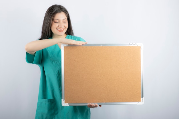 Smiling beautiful nurse holding board.