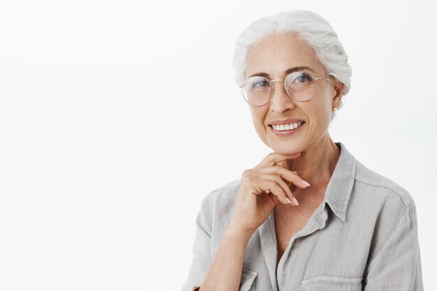 Smiling beautiful senior woman in glasses looking pleased