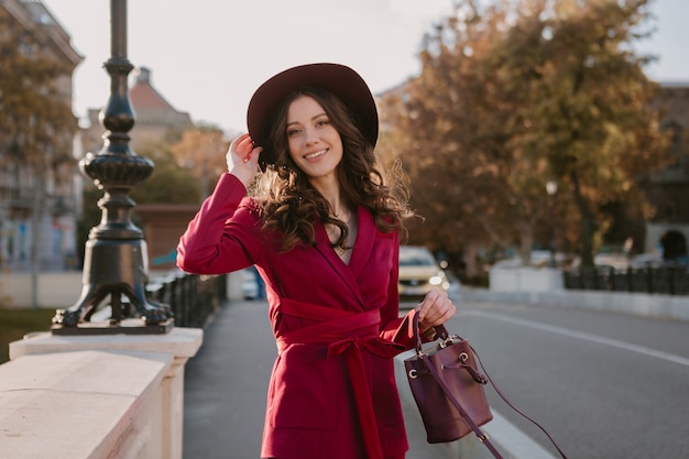 도시 거리, 봄 여름 가을 시즌 패션 트렌드 모자를 쓰고 지갑을 들고 걷는 보라색 정장에 웃는 아름다운 세련된 여자