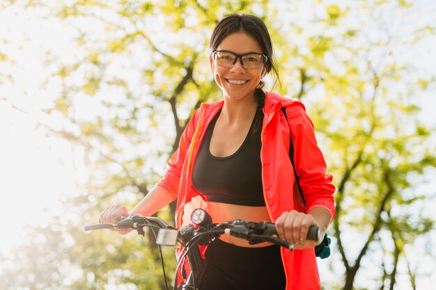 Smiling beautiful woman drinking water in bottle doing sports