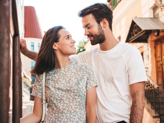 Smiling beautiful woman and her handsome boyfriend Woman in casual summer clothes Happy cheerful family Female having fun Couple posing on the street backgroundHugging each other