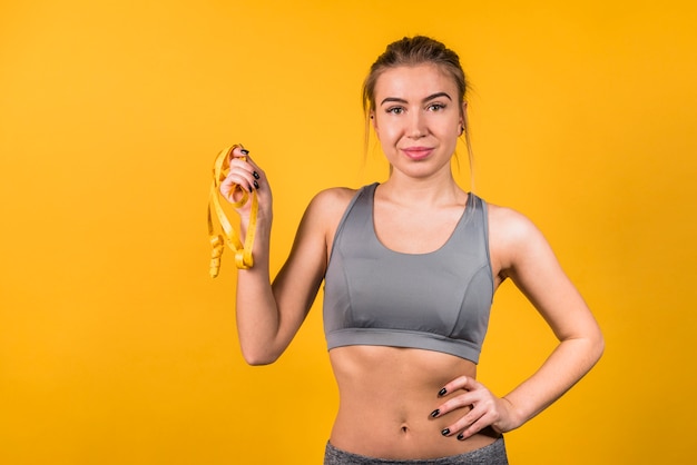 Smiling beautiful woman in sportswear with tape