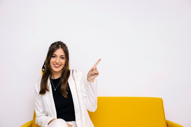 Smiling beautiful young woman pointing upward