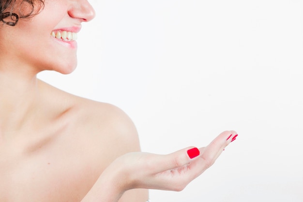 Free photo smiling beautiful young woman showing her hand against white background