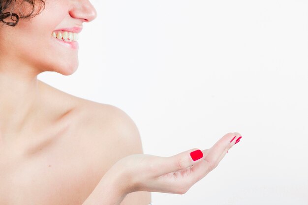 Smiling beautiful young woman showing her hand against white background