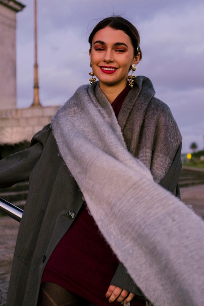 Smiling beautiful young woman with long scarf around her neck looking at camera