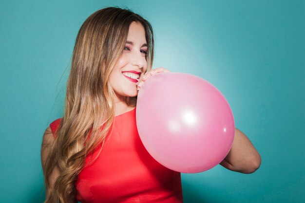 Smiling and bitting a balloon