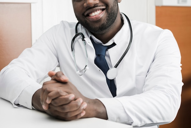 Smiling black doctor at table