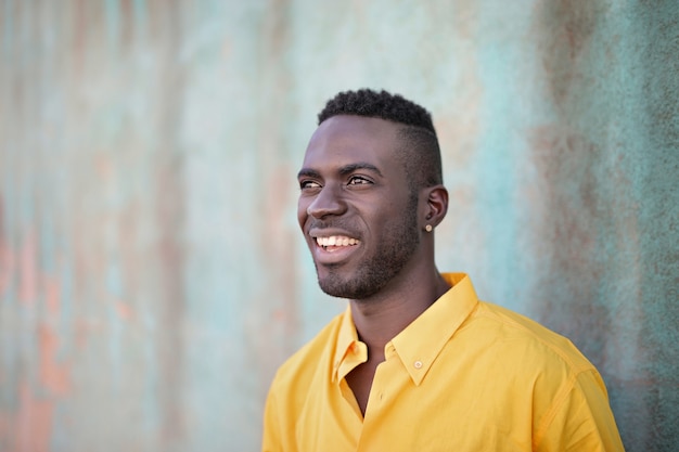 Smiling black man standing behind a wall