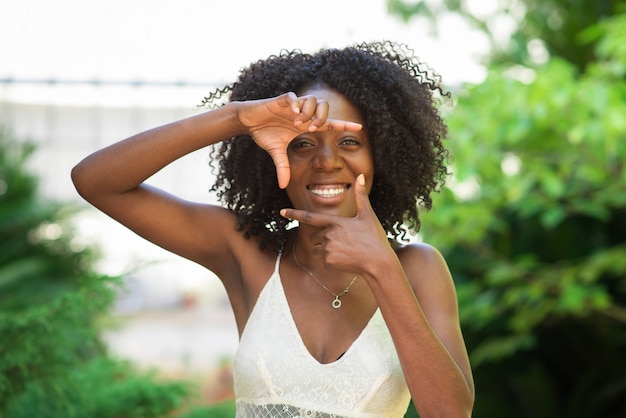 프레임 제스처를 만드는 흑인 여성 미소