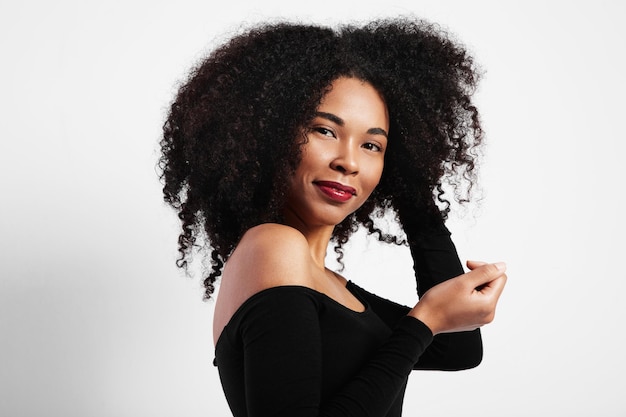 Smiling black woman touches her hair