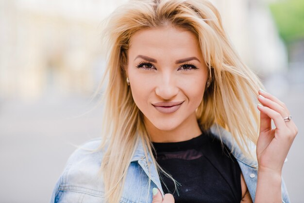 Smiling blonde girl standing on street