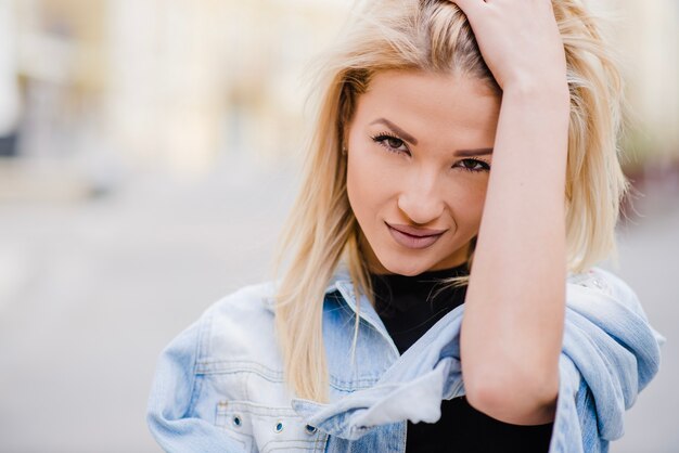 Smiling blonde girl standing on street