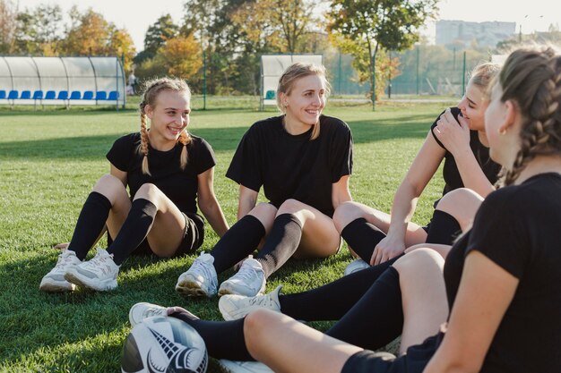 Smiling blonde girls sitting on grass