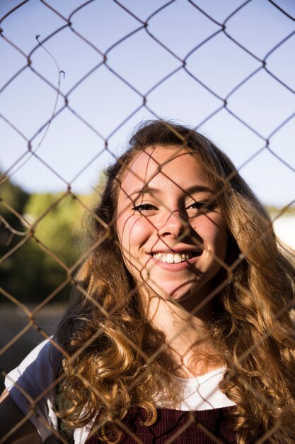 Smiling blonde through chain link