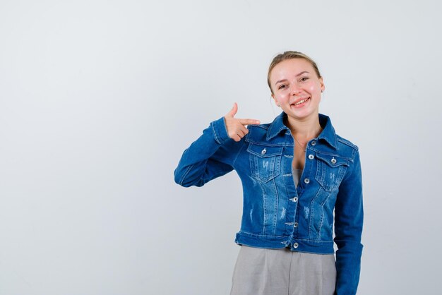 The smiling blonde woamn is showing perfect gesture with thumb on white background