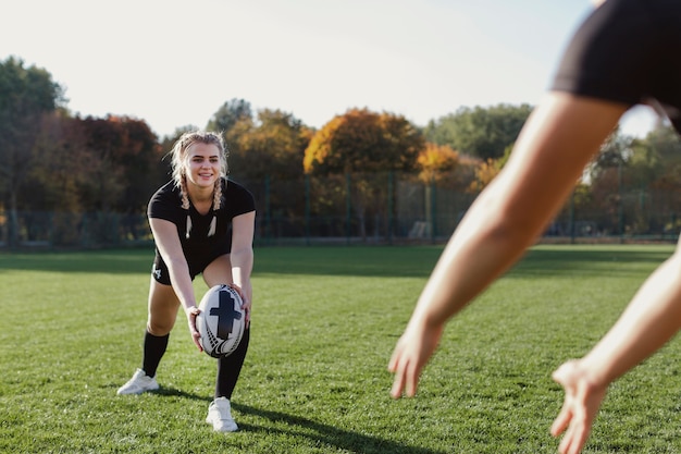 Free photo smiling blonde woman throwing a ball