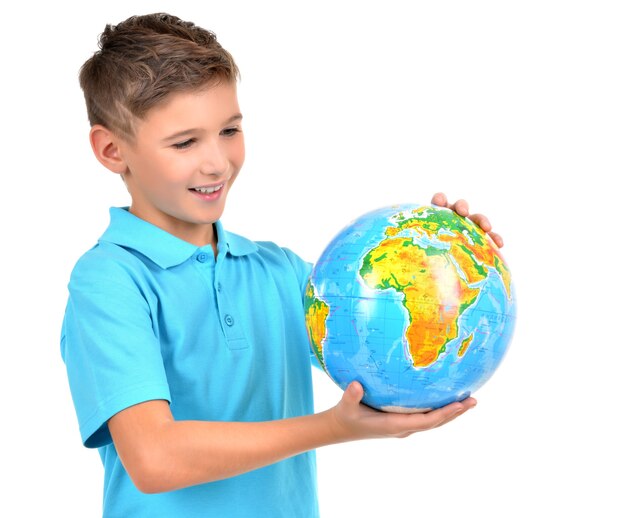Улыбающийся мальчик в случайном, держа в руках глобус, изолированные на белом