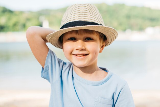 Smiling boy in hat enjoying sunlight