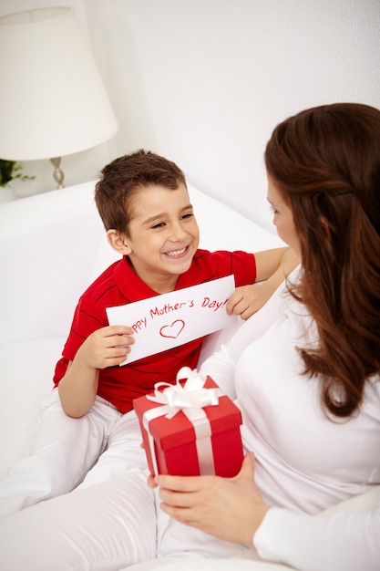 Ragazzo sorridente con un regalo per la madre