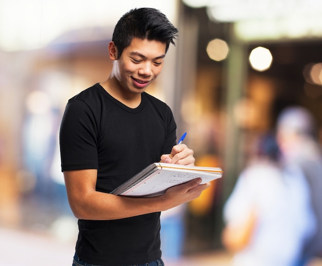 Smiling boy with notebook and pen