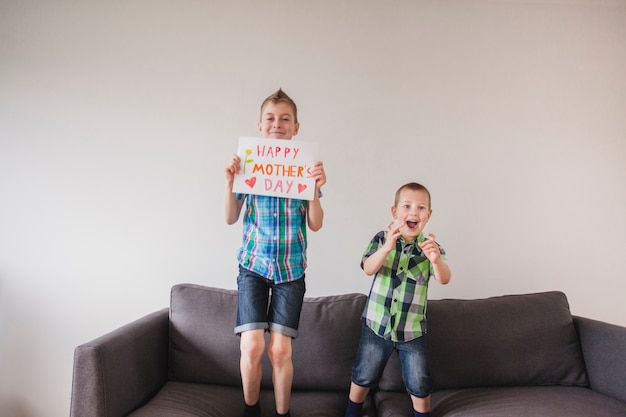 Smiling boys with mother's day poster