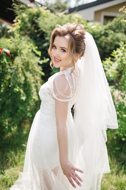 A smiling bride walks in the garden