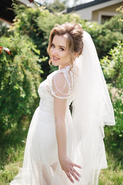 A smiling bride walks in the garden