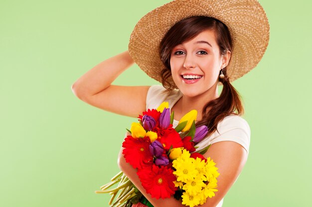 Smiling brunet woman with hat and spring flower