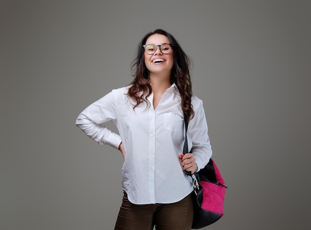 Smiling brunette female with a pink traveler bag.