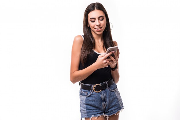 Smiling brunette scrolling social media on her phone isolated