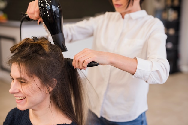 Smiling brunette woman getting her hair done