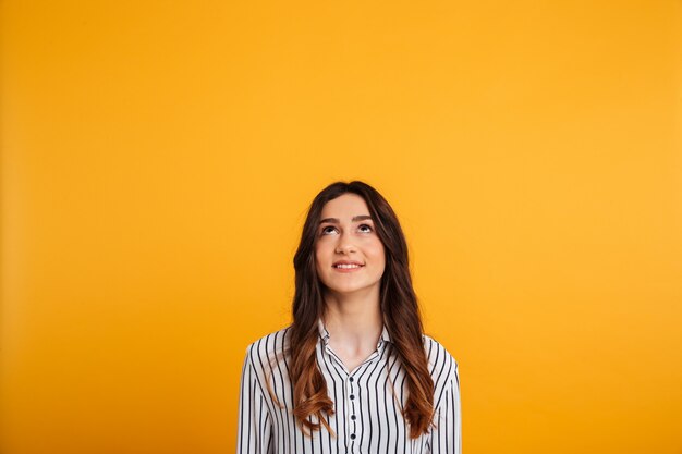 Smiling brunette woman in shirt looking up