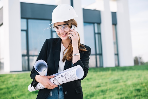 Smiling builder woman talking on phone