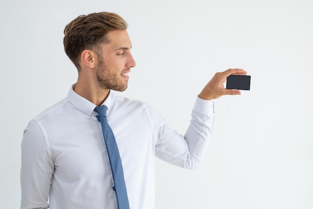 Smiling business leader showing blank business card