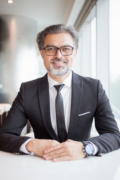 Smiling Business Man Sitting at Empty Office Desk