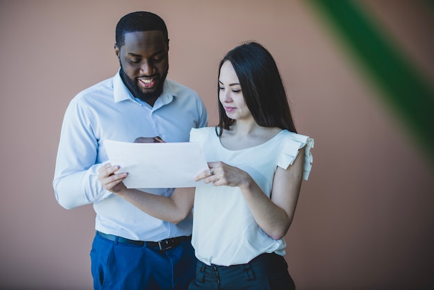 Free photo smiling business man and woman with paper