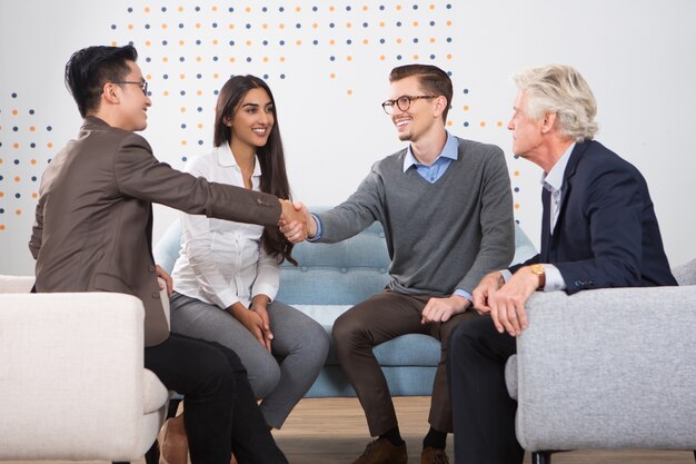 Smiling Business Partners Shaking Hands in Lounge