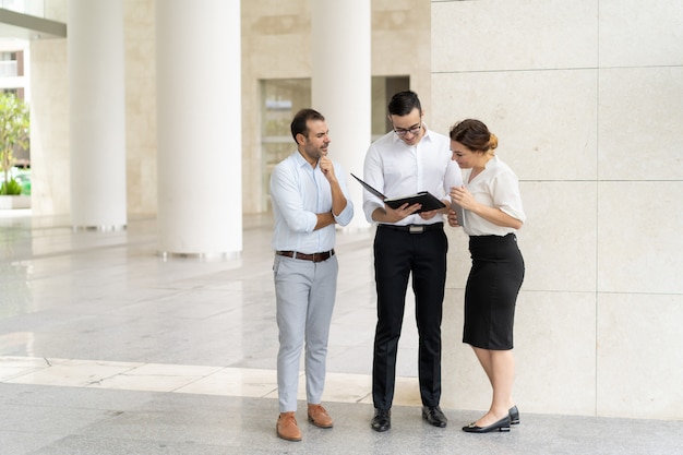 Smiling business team examining documents before meeting