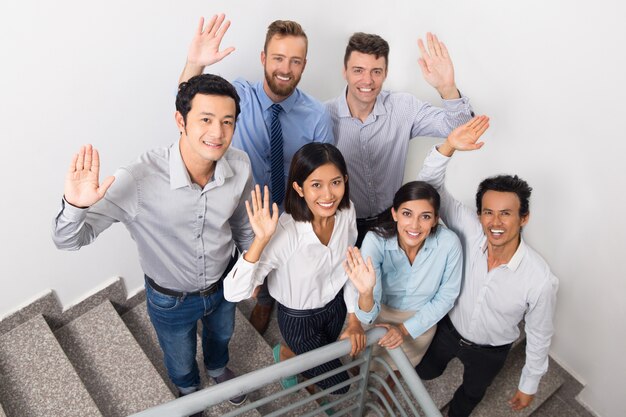 Smiling Business Team Saluting on Office Stairs