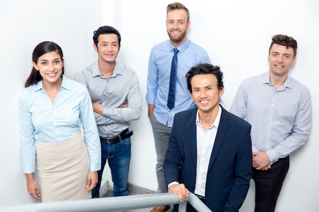 Smiling Business Team Standing on Office Stairway