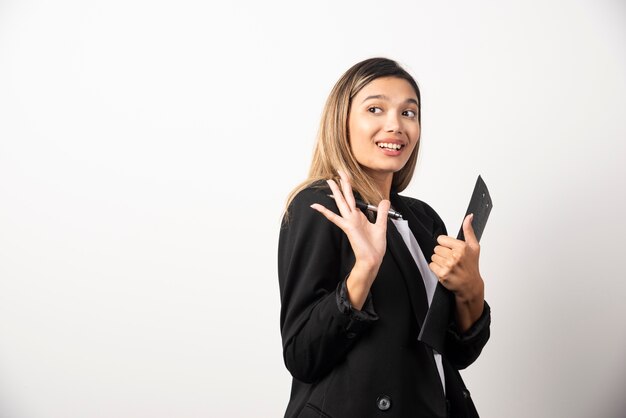 Smiling business woman holding clipboard . 